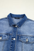 Close-up of a blue denim jacket with white buttons on a light gray background