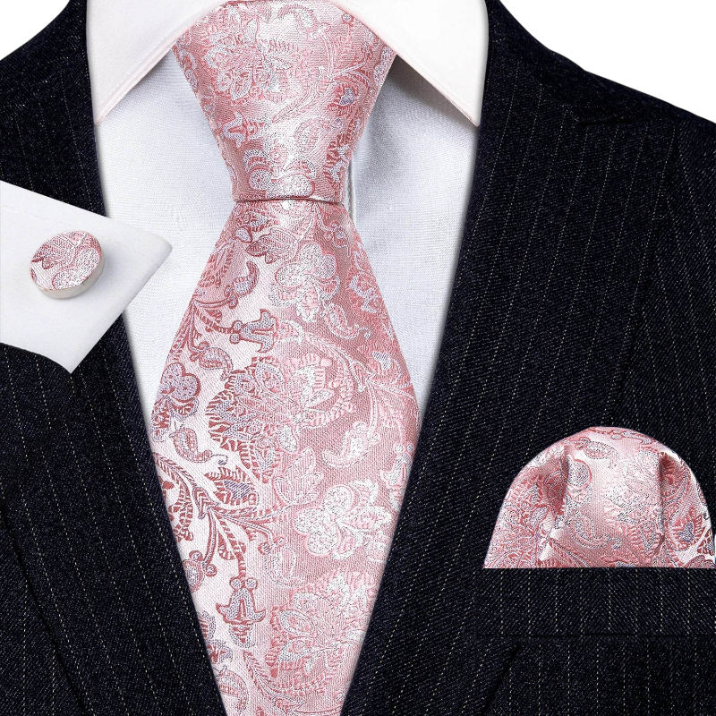 Pink paisley tie set with matching pocket square and cufflinks on a black suit.