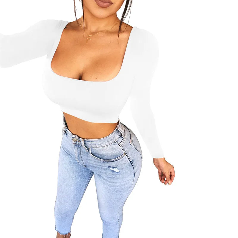 Woman wearing a white sexy summer crop top for women paired with light blue high-waisted jeans